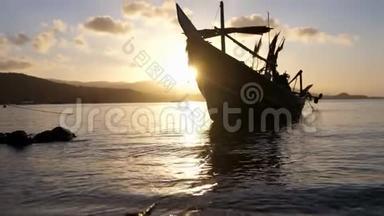 在群山和美丽的日落的背景下，船停泊在岸边。 浪漫的气氛。 冷静和冷静